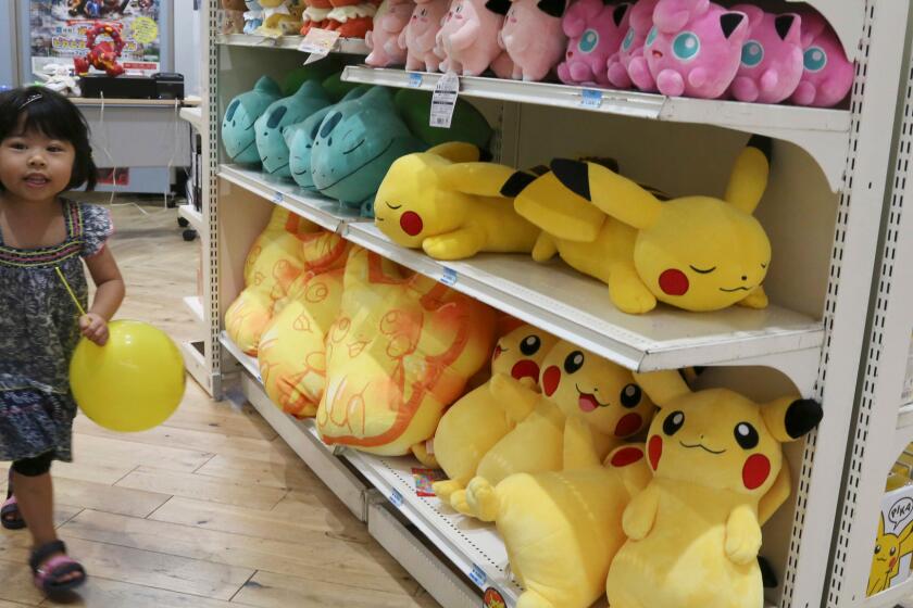 A girl walks past Pokemon characters for sale during a Pokemon festival in Tokyo.