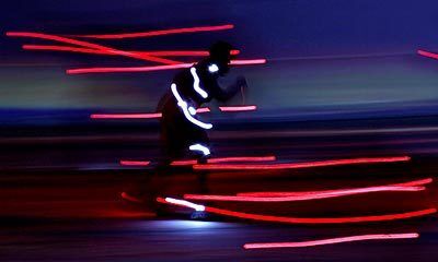 A rollerblader creates a blur of light along with dozens of others.