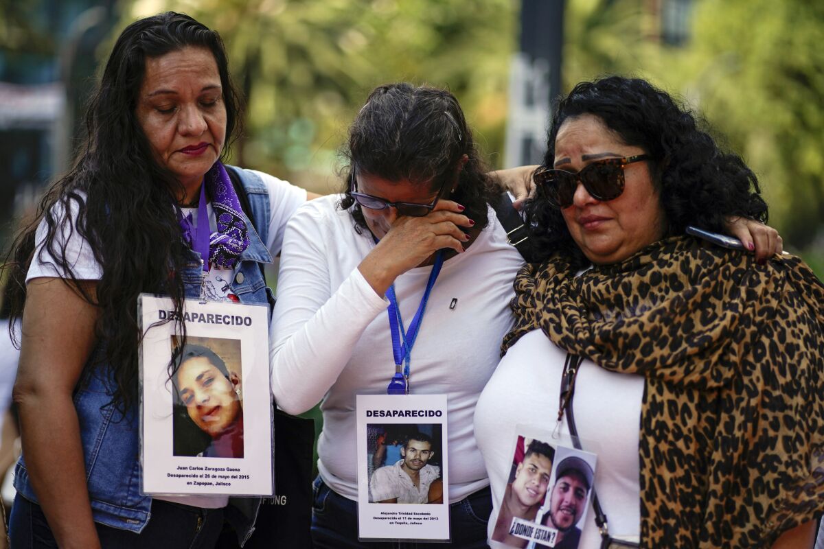 Personas con fotos de desaparecidos asisten a una marcha en el Día Internacional de las Víctimas