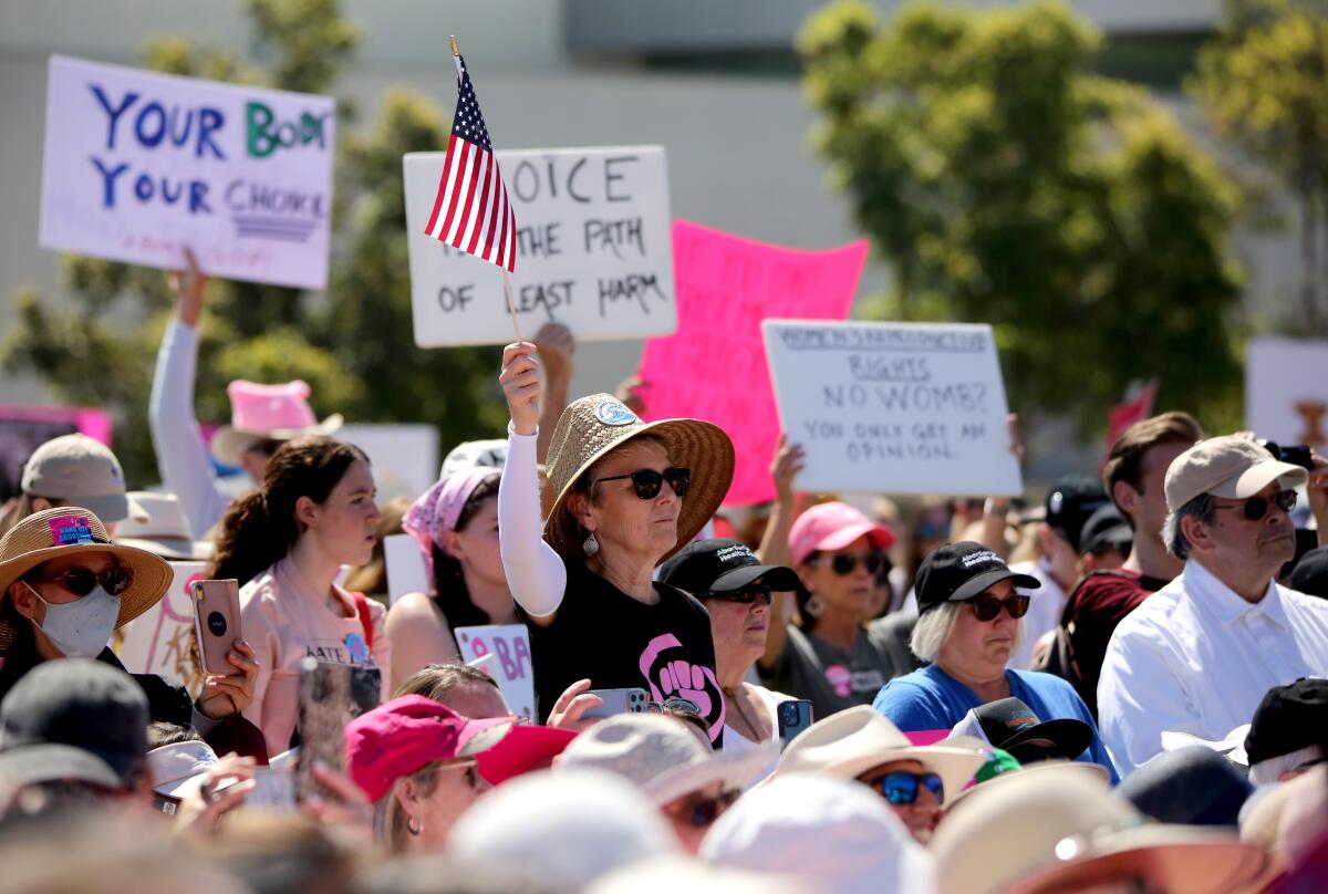Jacqueline Staggs of San Clemente waves a flag at a "Bans Off Abortion" rally at Centennial Regional Park in Santa Ana.