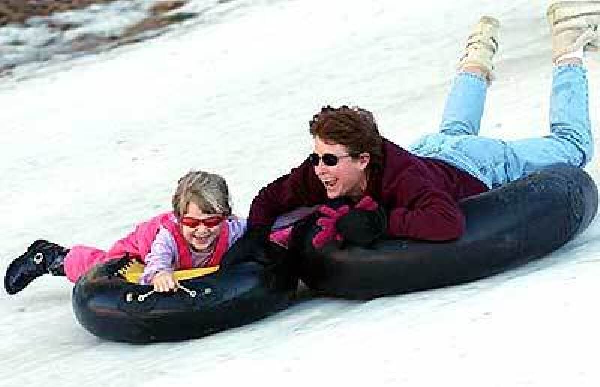 Visitors slide down the hill at Snowdrift Winter Park outside Running Springs.