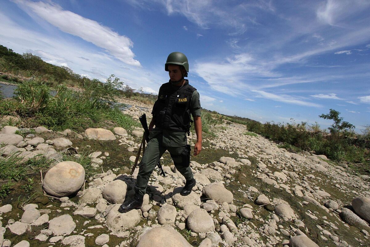 A member of the Venezuelan National Guard patrols along the Tachira River, which forms the border with Colombia, on Sept. 5, 2014. The low prices for gasoline and basic goods in Venezuela encourages the flow of scarce commodities into neighboring Colombia.