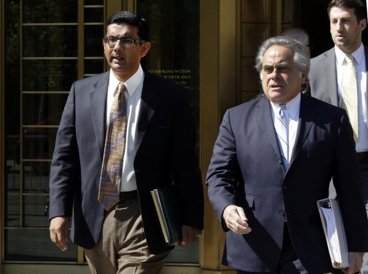 Dinesh D'Souza, left, accompanied by his lawyer, leaves federal court in New York in 2014.