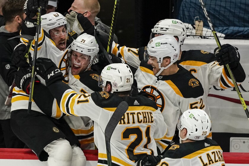 Boston Bruins center Brad Marchand, left, celebrates with teammates after scoring the winning goal in overtime of Game 2 of an NHL hockey Stanley Cup first-round playoff series against the Washington Capitals, Monday, May 17, 2021, in Washington. (AP Photo/Alex Brandon)