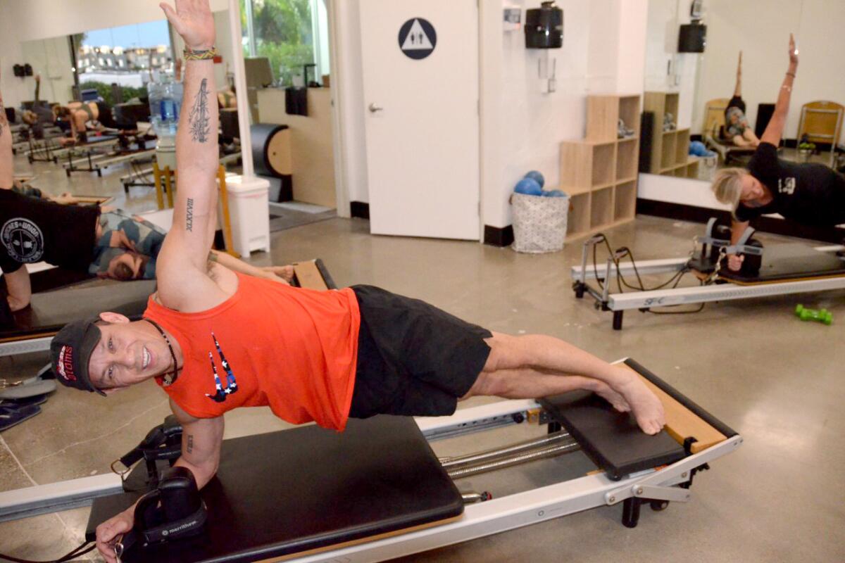 Mitchell Bryant does a side plank on the reformer during class at Escape Pilates in Costa Mesa.