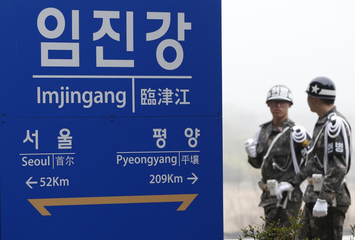 South Korean soldiers walk by a signboard showing the distance to the North Korea's capital Pyongyang and to South Korea's capital Seoul from Imjingang Station near the border village of the Panmunjom in Paju, South Korea on April 9.