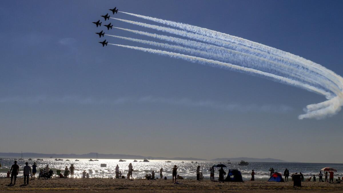 U.S. Air Force Thunderbirds take part in an airshow in the skies over Huntington Beach. The city is being sued by the state — and countersuing — over housing laws.
