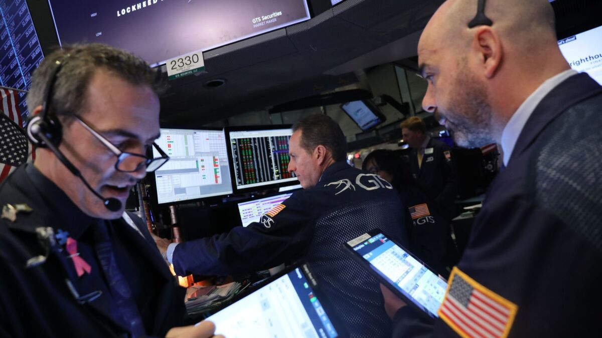 The Dow Jones industrial average fell 0.3% to 26,341.02 on Monday. Above, traders work on the floor of the New York Stock Exchange.