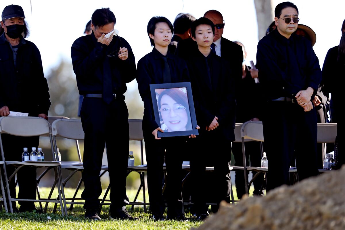 A person holds photo during her funeral service.