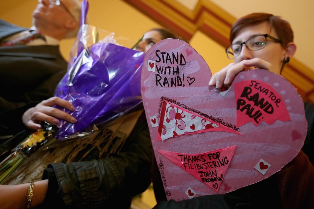 Code Pink's Dooler Campbell, right, signs a card of thanks for U.S. Sen. Rand Paul (R-Ky.) as activists deliver flowers, candies and other objects of thanks to the senator's Captiol Hill offices. A traditionally liberal demonstration organization, Code Pink was thanking conservative Paul for his nearly 13-hour filibuster of the confirmation vote on John Brennan to become the next Central Intelligence Agency director.