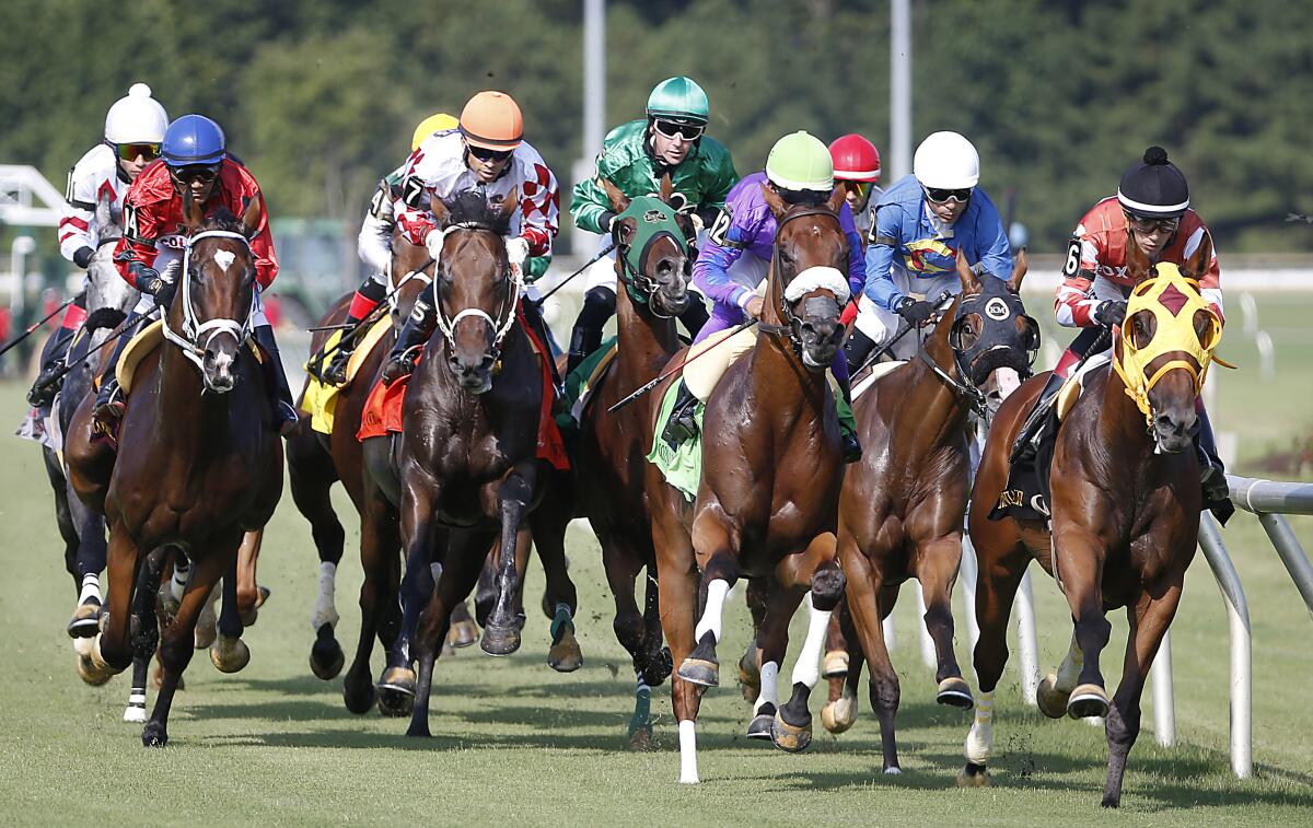 Horses head down the track during the first race on Colonial Downs' opening day of the season near New Kent, Va., on Thursday.