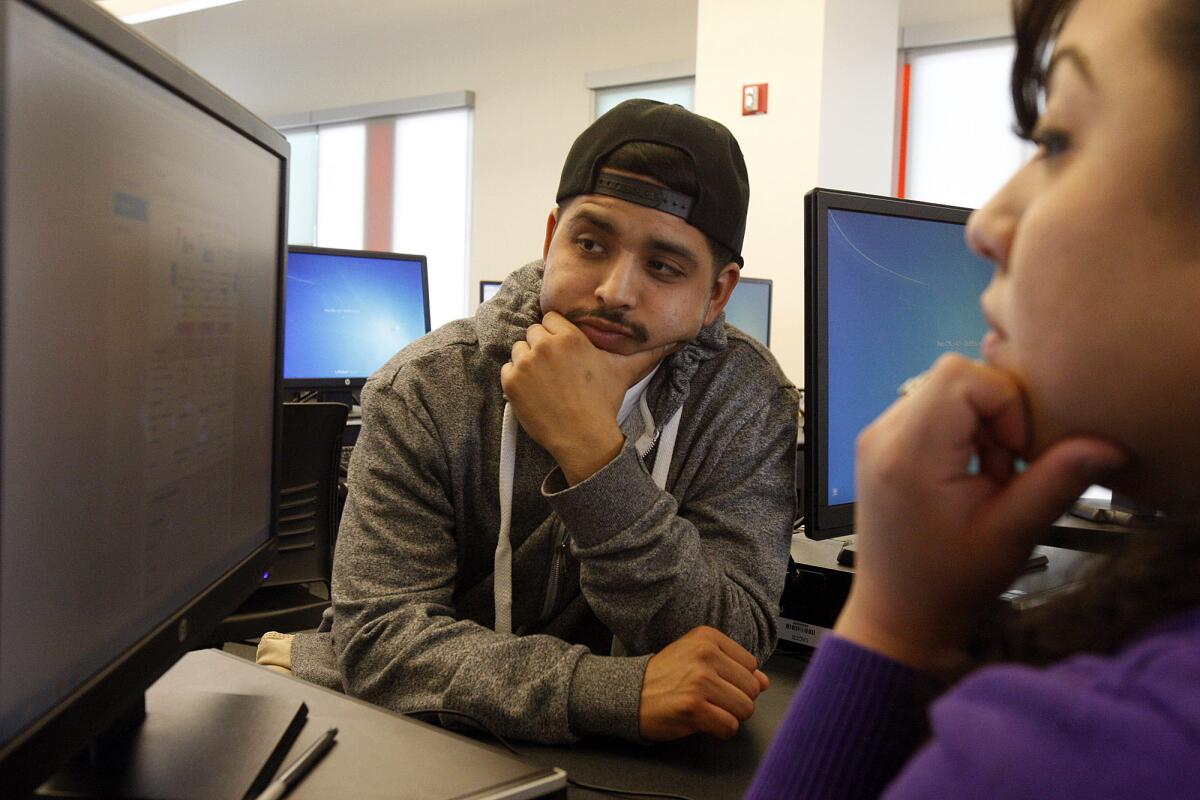 Josué Ontiveros, a la izquierda, se inscribe en un seguro de salud bajo Covered California con Nicole Rivas, una consejera de inscripción certificada, en Los Angeles Trade-Technical College en Los Ángeles en 2016.