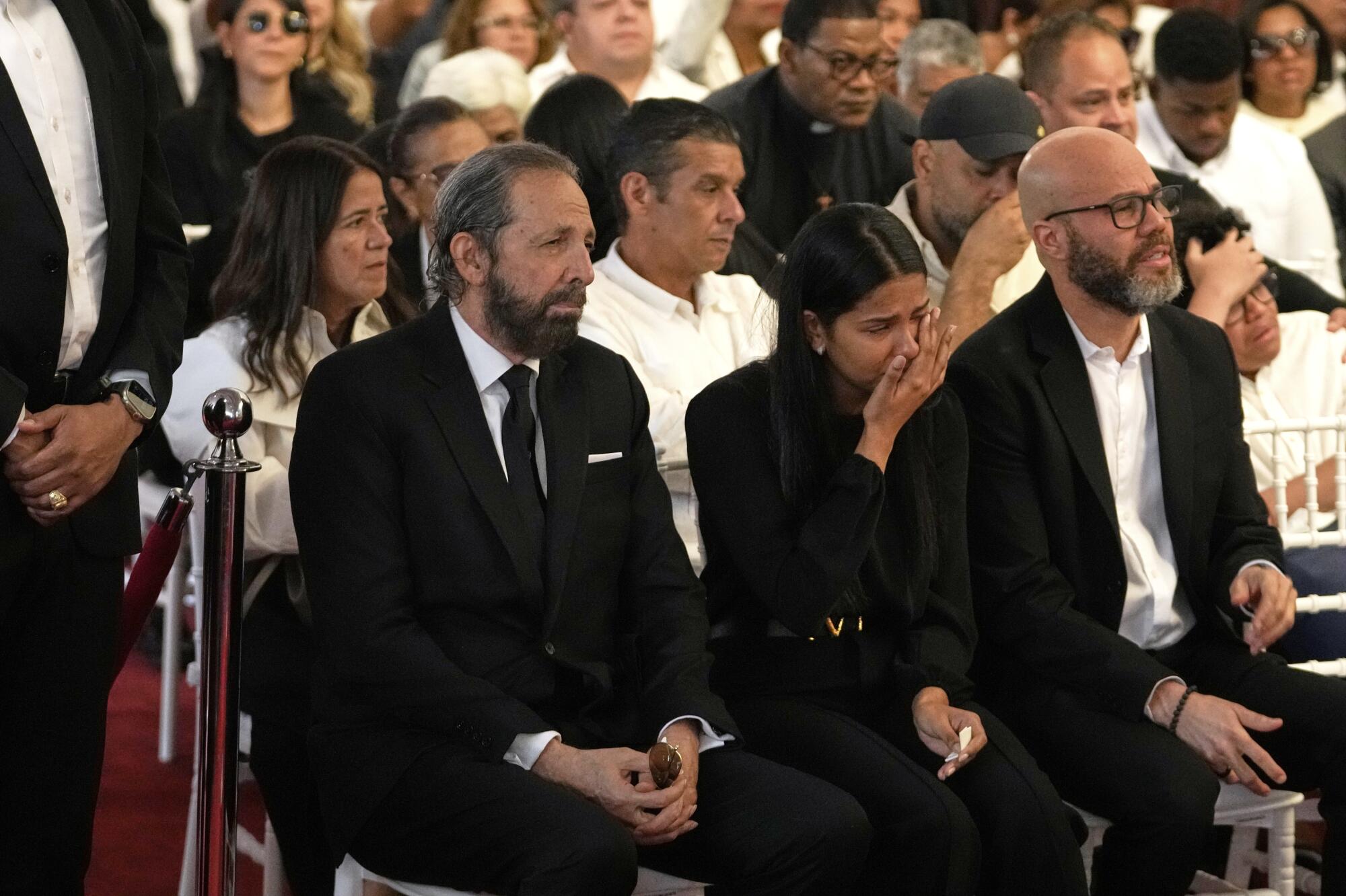 El cantante dominicano Juan Luis Guerra, a la izquierda, asiste al velorio