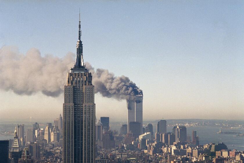 FILE - In this Sept. 11, 2001, file photo, the twin towers of the World Trade Center burn behind the Empire State Building in New York. The Sept. 11, 2001 terrorist attack is by far the most memorable moment shared by television viewers during the past 50 years, a study released on Wednesday, July 11, 2012, concluded. (AP Photo/Marty Lederhandler, File)