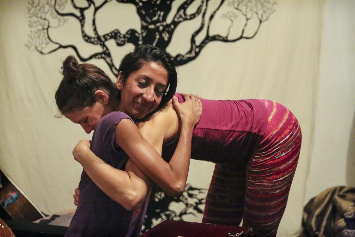 Cheri Rae Russell, bent over at right, embraces musician Sheela Bringi at Peace Yoga Gallery, which opened in 2006. The landlord recently told Russell that he hopes to raise the rent from 25 cents to $4 a square foot when her lease is up in a few years. She isn't going to worry about that: "I'm just enjoying the here and now."