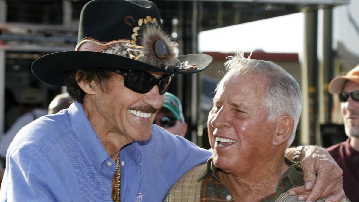 David Pearson, right, and his longtime rival Richard Petty share a laugh during practice for a NASCAR Sprint Cup race. Pearson has died at 83.