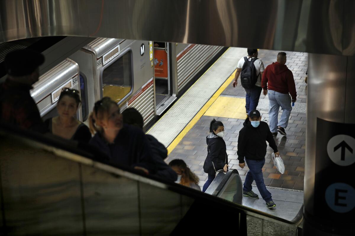 Metro riders depart the Red Line subway platform at the Figueroa and 7th St station