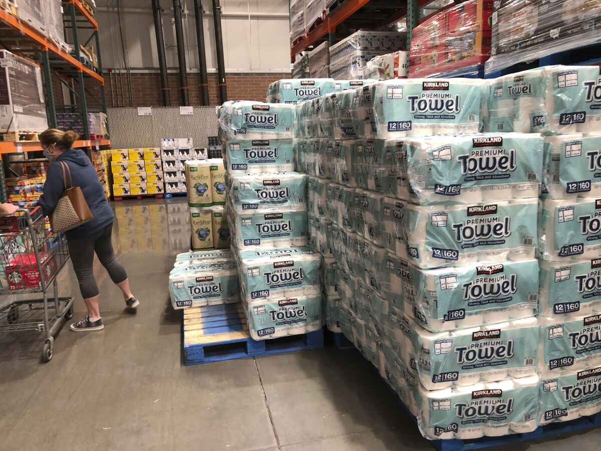 A shopper loads her basket next to a display of paper towels in a Costco warehouse in this photograph taken Wednesday, Nov. 18, 2020, in Sheridan, Colo. U.S. consumer prices edged up 0.2% in November as a rise in energy costs and variety of other items offset a drop in food costs. The Labor Department reported on Thursday, Dec. 10, that the gain in the consumer price index followed an unchanged reading in October and matched the 0.2% September advance. (AP Photo/David Zalubowski)