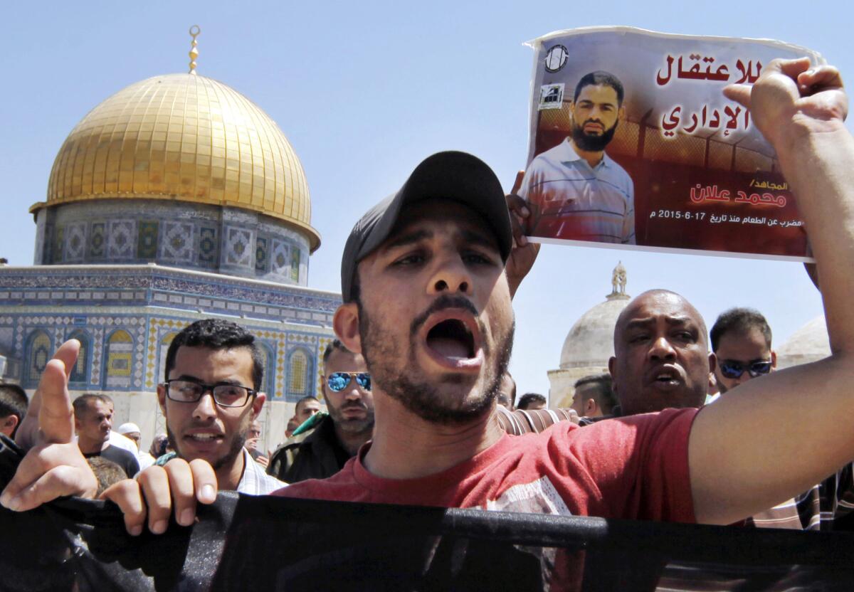 Palestinian demonstrators chant slogans and carry a poster of hunger striker Mohammed Allan during a protest in Jerusalem's Old City on Aug. 14.
