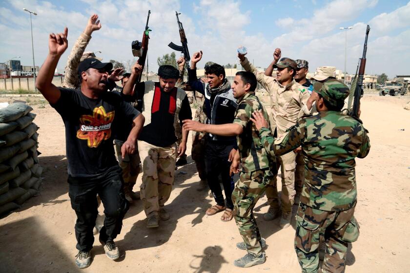 Iraqi fighters chant slogans against extremists.