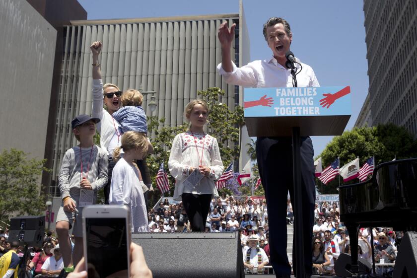 FILE - Then California Lt Gov. Gavin Newsom, right, with his wife, Jennifer Siebel Newsom and their children, speak at the "Families Belong Together - Freedom for Immigrants March" in downtown Los Angeles on June 30, 2018. California Gov. Gavin Newsom has left the state with his family for a trip to Mexico during Thanksgiving. The Governor's Office announced the trip on Monday, Nov. 22, 2021, hours after Newsom held a news conference at a vaccine clinic in San Francisco. California's Constitution requires the lieutenant governor to serve as "acting governor" whenever the governor leaves the state. The Governor's Office usually announces anytime Newsom leaves the state, even if just for a few hours. (AP Photo/Damian Dovarganes, File)