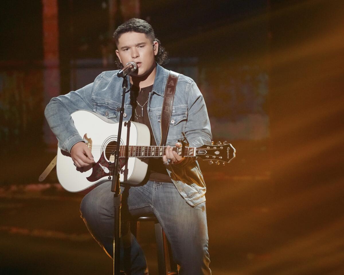 Caleb Kennedy holding a guitar