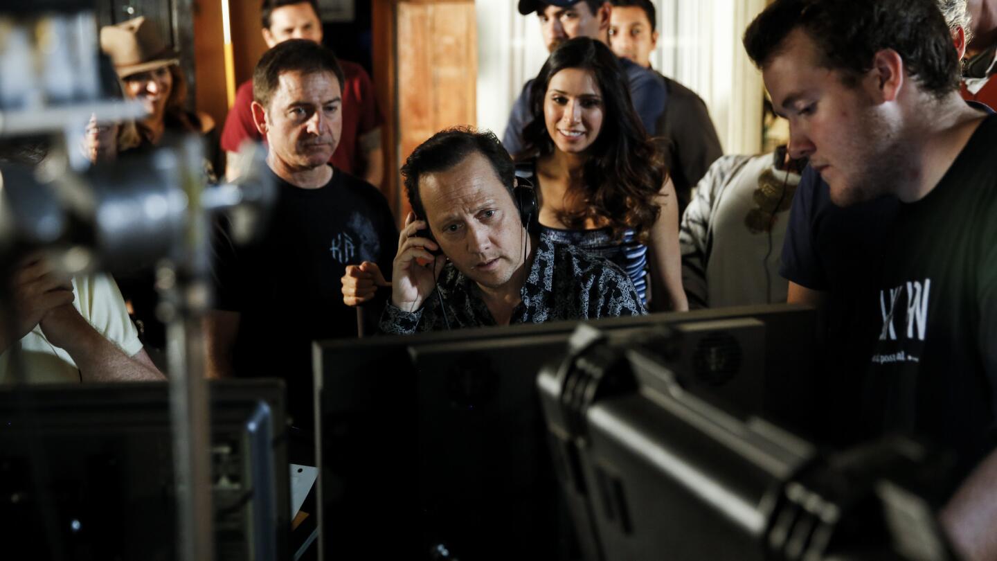 Rob Schneider, center, watches a playback of a scene he acted in and directed for his self-financed sitcom "Real Rob" at Los Angeles Film School in Hollywood.