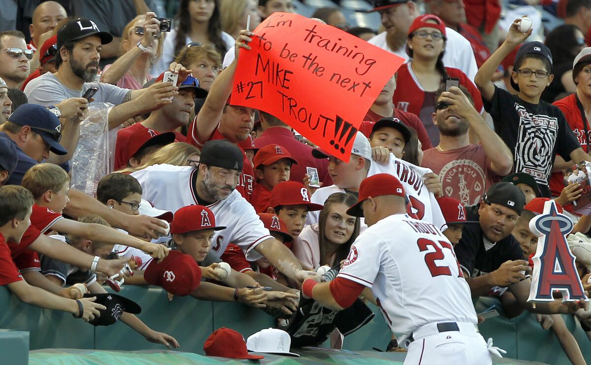 Mike Trout signs autographs as fans line up prior to a game against the Texas Rangers on May 2.
