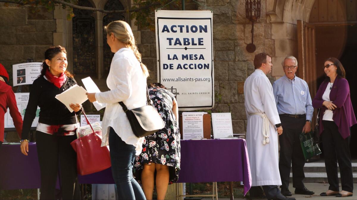 Parishioners chat near the Action Table outside of All Saints Church in Pasadena after a service on Sunday, Dec. 3.