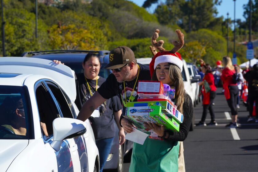 San Diego, CA - December 11: At the 25th Annual Toys for Joy at the Mesa College campus on Saturday, Dec. 11, 2021 in San Diego, CA., an army of volunteers helped distribute food and toys to more than 3000 family members. (Nelvin C. Cepeda / The San Diego Union-Tribune)