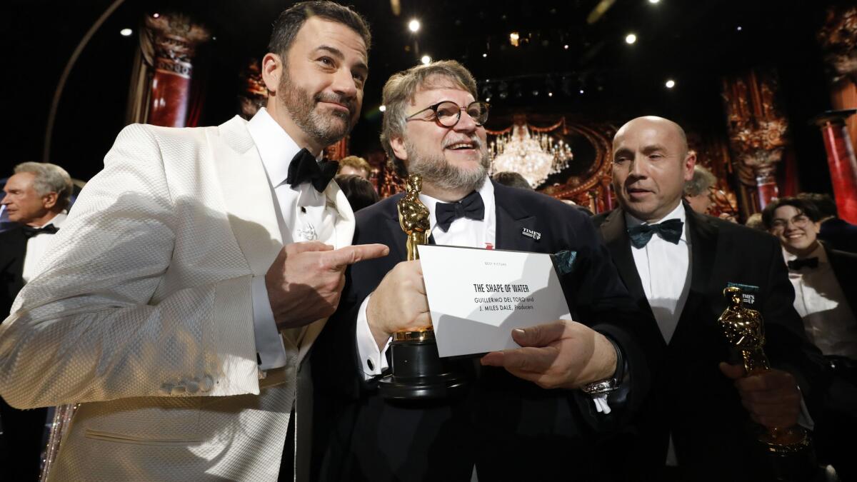 Host Jimmy Kimmel and Oscar winner Guillermo del Toro are shown with producer J. Miles Dale backstage at last year's Academy Awards.