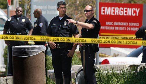 Police guard an entry to the Long Beach Memorial Medical Center after a hospital employee shot two other employees, then killed himself. One of his victims died at the scene; the other died later.