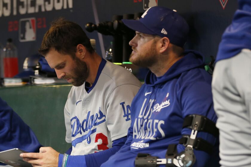 Los Angeles Dodgers' Gavin Lux, from second from left, sits on the bench with Chris Taylor.
