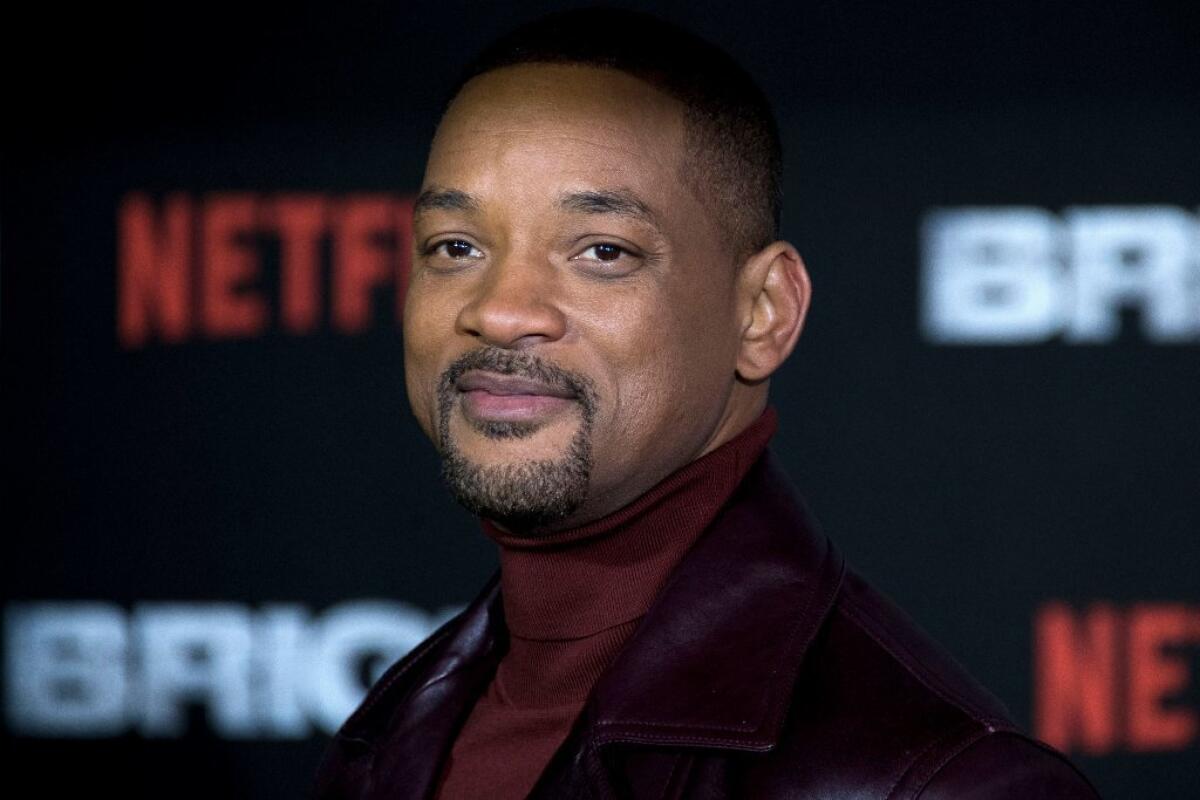 Will Smith in a red turtleneck and black jacket