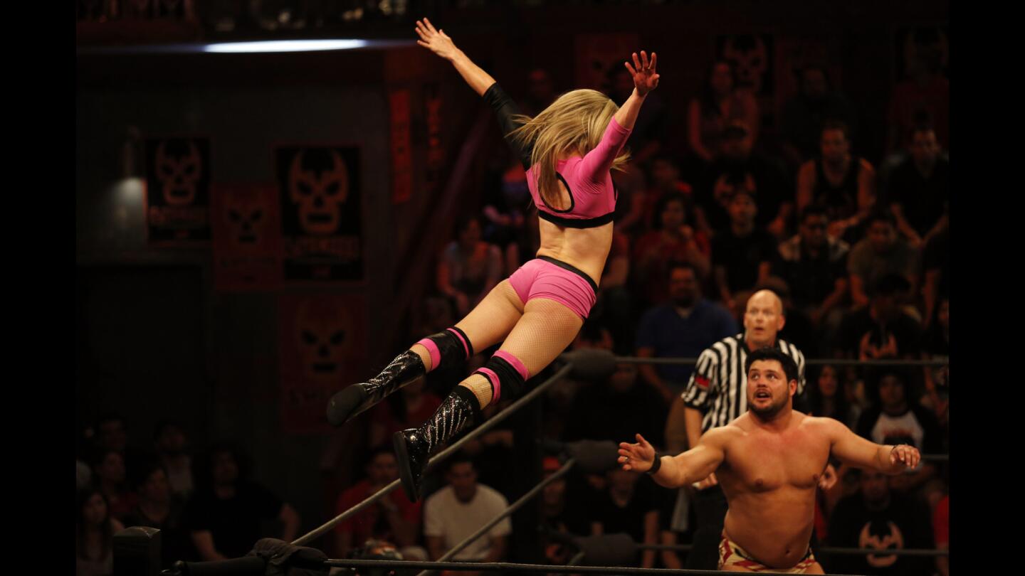Sexy Star, a la izquierda, hace una acrobacia en la pelea contra Marty "The Moth" Martínez, durante una función de lucha libre en Boyle Heights.