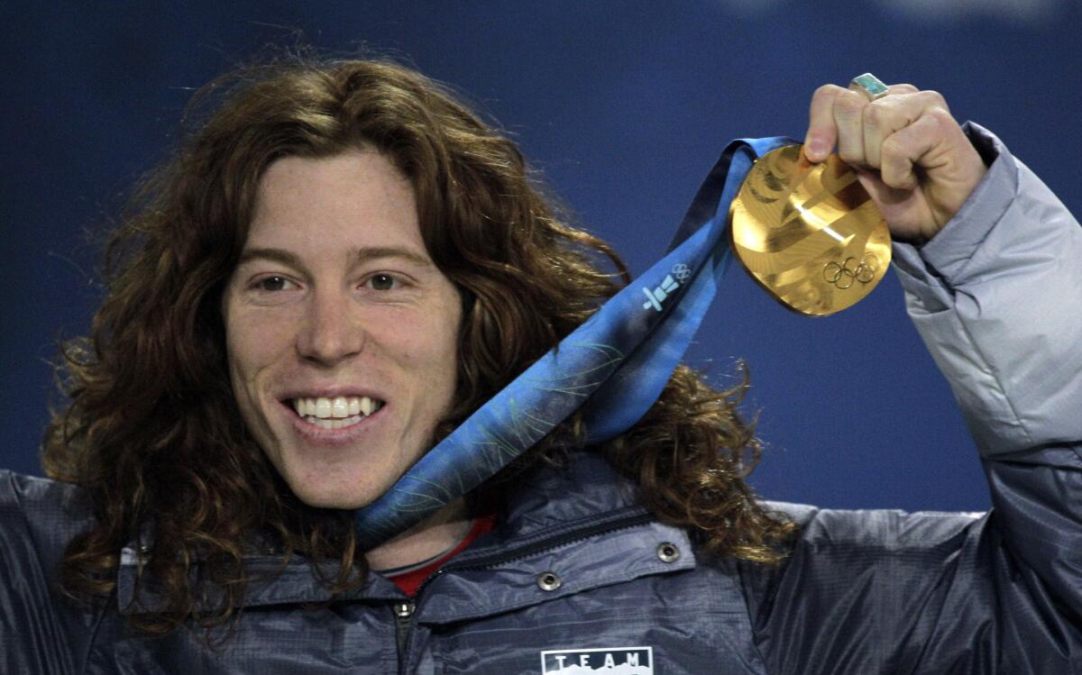 Shaun White holds up a gold medal at the 2010 Olympics.