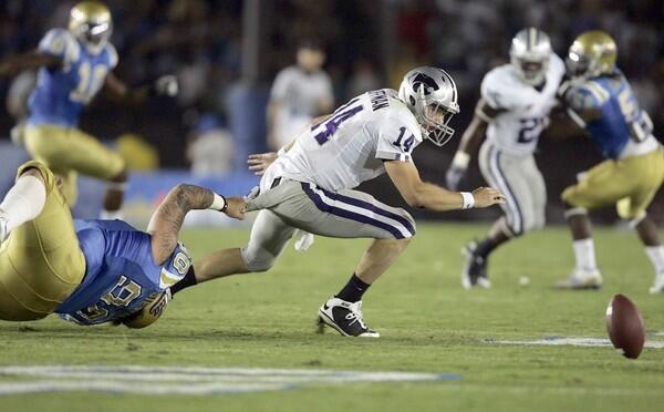 Kansas State quarterback Carson Coffman fumbles as he pulled down by UCLA's Jerzy Siewierski in the second quarter Saturday.