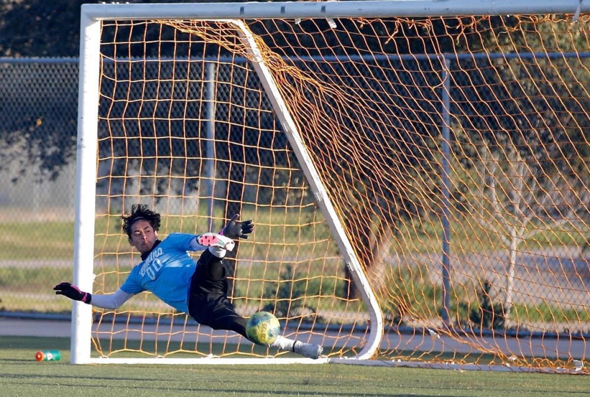 Matthew Ceja of El Camino Real comes up with save by deflecting ball with his foot on Palisades' first penalty-kick attempt.