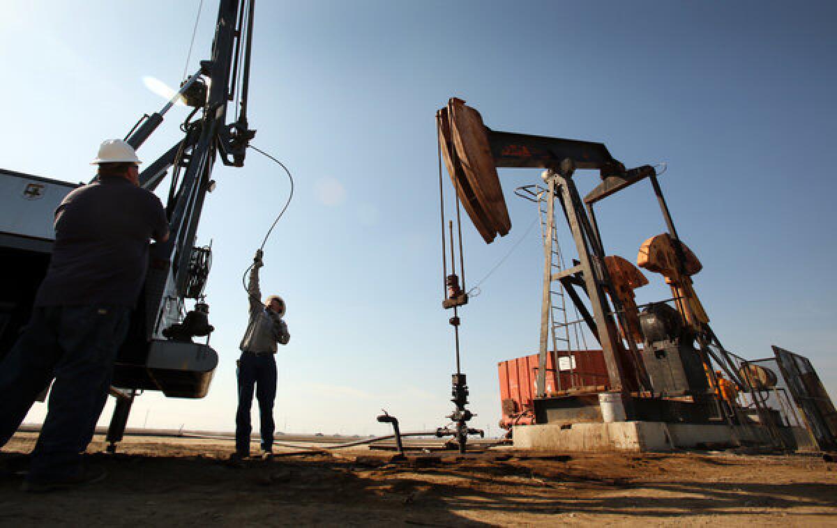 A wireline operator prepares a slick line at an oil pump jack site in the oil fields near Bakersfield.