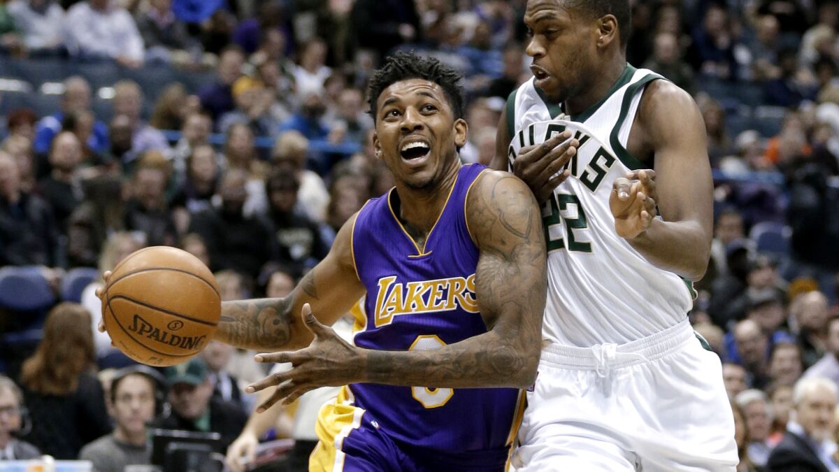 Lakers guard Nick Young drives down the lane against Bucks guard Khris Middleton during the first half of their game in Milwaukee on Feb. 10, 2017.