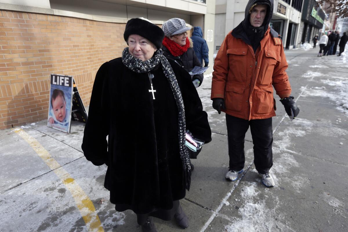Eleanor McCullen of Boston, left, stands at the painted edge of a buffer zone outside a Planned Parenthood location in Boston.