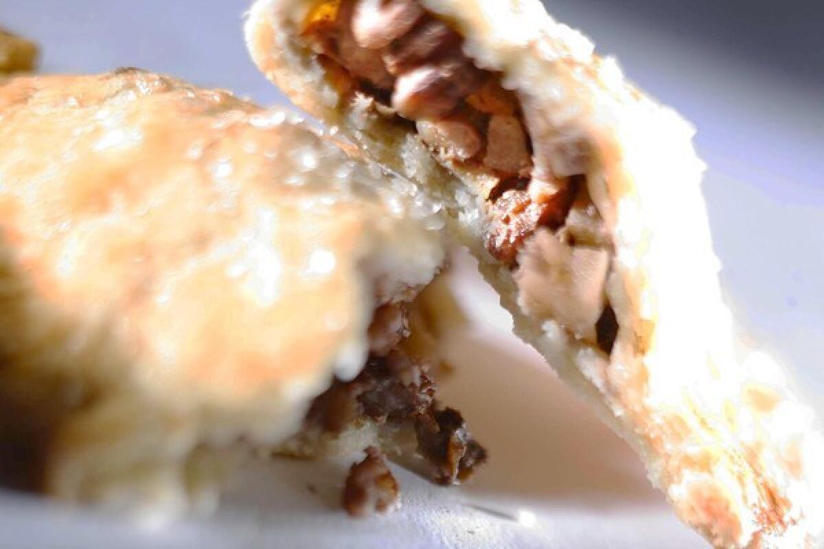 A flaky hand pie is filled with apples, rum raisins and pecans.