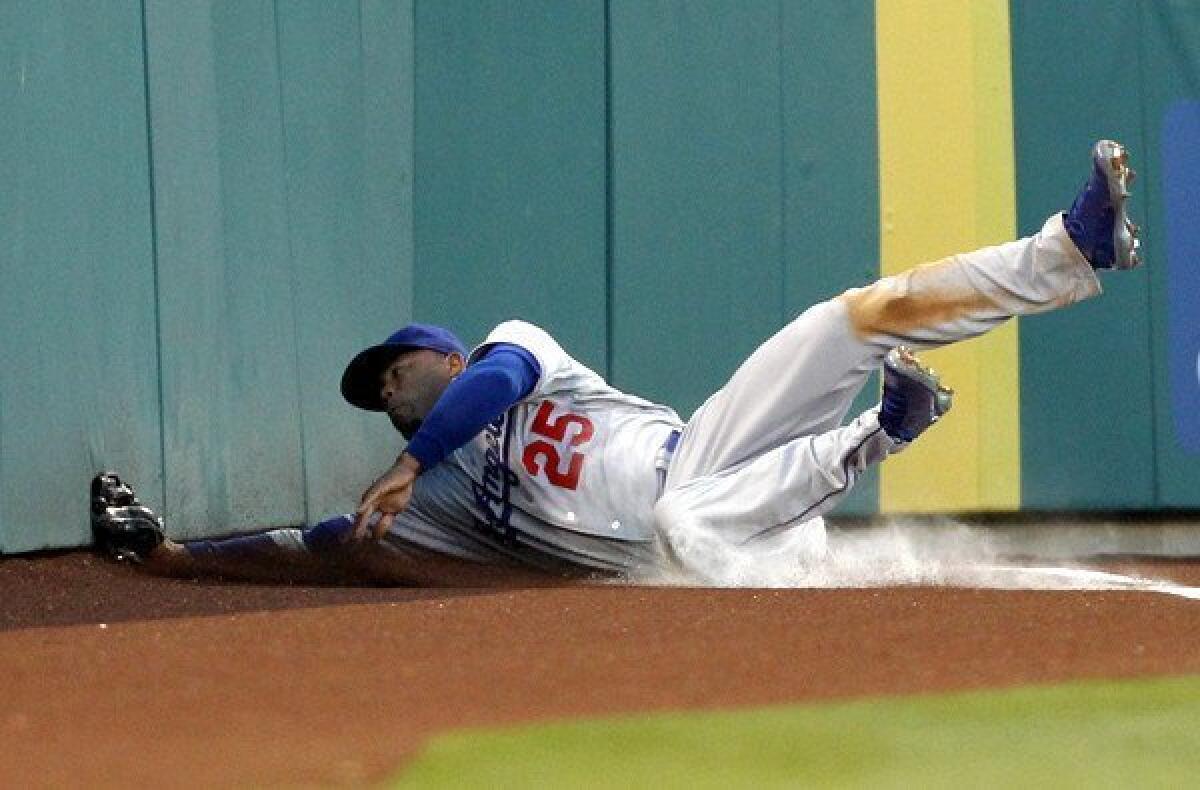 Dodgers left fielder Carl Crawford slides hard into the wall after making a diving catch of a fly ball by Angels third baseman Alberto Callaspo in the second inning Thursday night.