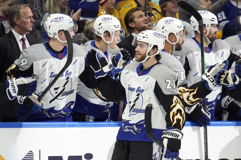 Tampa Bay Lightning center Brayden Point (21) celebrates with the bench after his goal against the Nashville Predators during the first period of an NHL hockey game Thursday, Dec. 8, 2022, in Tampa, Fla. (AP Photo/Chris O'Meara)