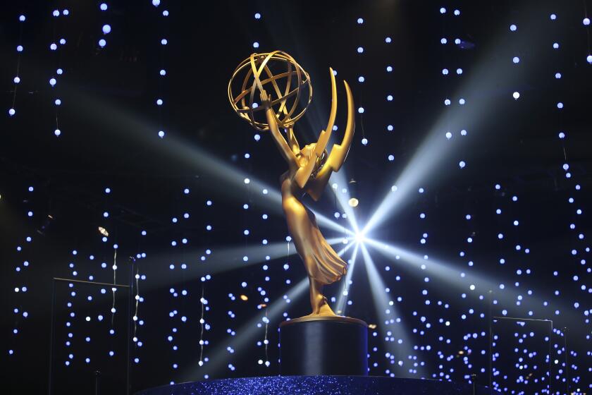 A golden statue sits on a pedestal with a light shining behind it