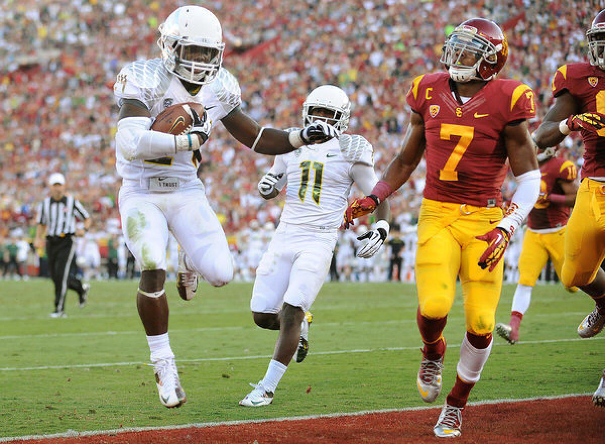 Ducks running back Kenjon Barner, who scored five touchdowns, beats Trojans safety T.J. McDonald to the end zone in the second quarter Saturday.
