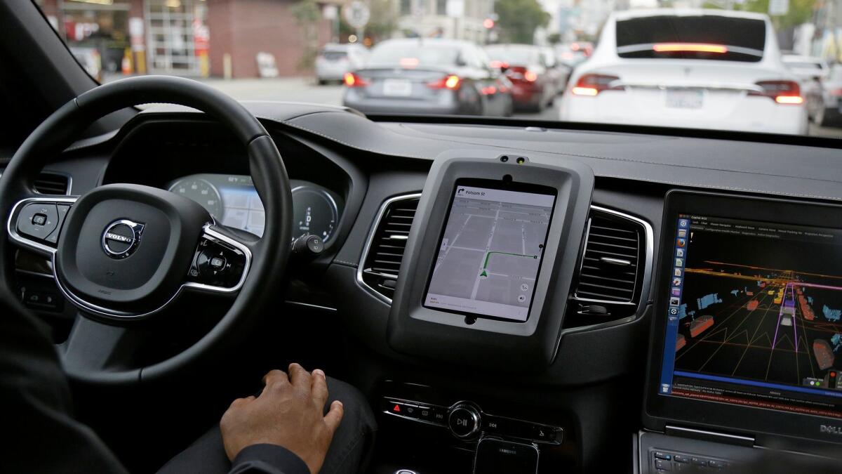 An Uber driverless car waits in traffic during a test drive in San Francisco on Dec. 13. The ride-hailing company is refusing to obey demands by the state's Department of Motor Vehicles that it stop picking up San Francisco passengers in specially equipped Volvo SUVs.