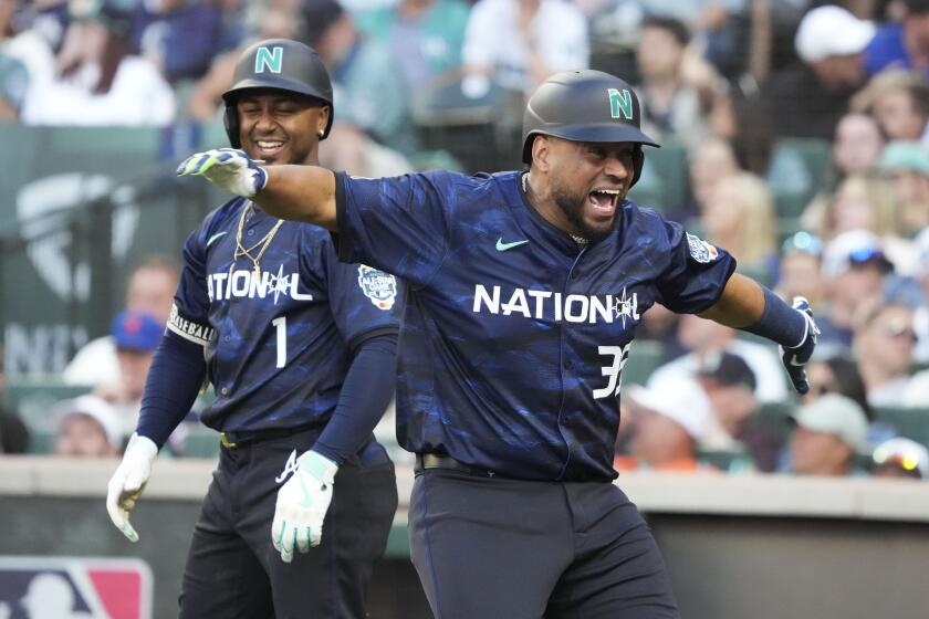 National League's Elias Díaz, of the Colorado Rockies, celebrates his two run home run with Ozzie Albies, of the Atlanta Braves, in the eighth inning during the MLB All-Star baseball game in Seattle, Tuesday, July 11, 2023. (AP Photo/Ted S. Warren)