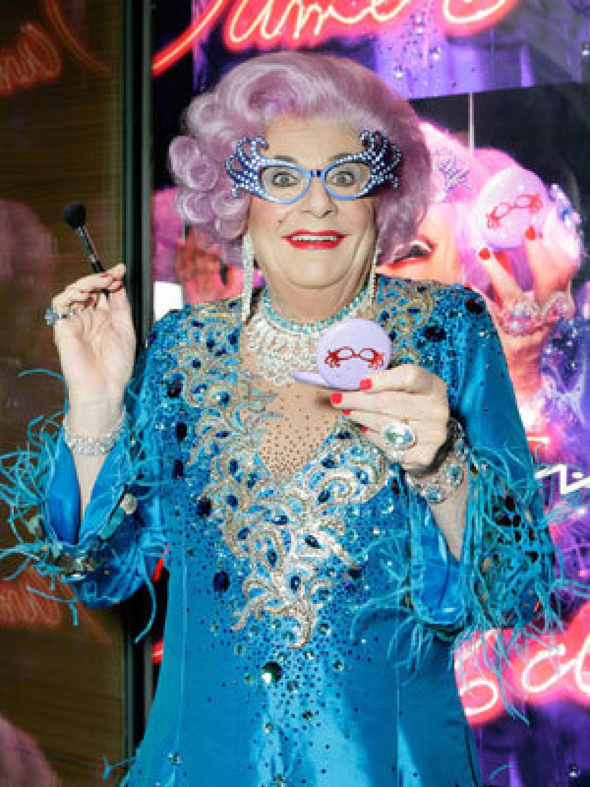 RHINESTONE DIVA: The lilac-haired Dame Edna Everage tries out some of the products in her new line at the MAC Robertston Store in Beverly Hills.