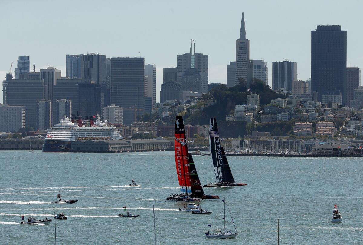Emirates Team New Zealand, left, races against Oracle Team USA in San Francisco Bay on Thursday.